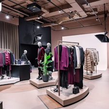 The BOSS Studio in Zurich embodies an avant-garde retail concept within a 250-square-meter space. With a nod to the brand's essence, a vibrant customisation corner and captivating window displays adorned with flashlights enchant passersby. Retail design by Studio Königshausen.